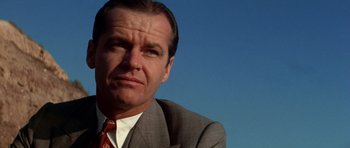 Movie still from “Chinatown” (1974), directed by Roman Polanski – A person wearing a suit and tie; Close Up shot, Low angle