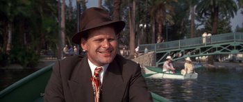 Movie still from “Chinatown” (1974), directed by Roman Polanski – A man wearing a suit and tie and a hat; Close Up shot, Over the shoulder angle
