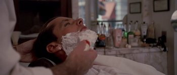 Movie still from “Chinatown” (1974), directed by Roman Polanski – A man is shaving his face with a razor; Close Up shot, Over the shoulder angle