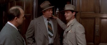 Movie still from “Chinatown” (1974), directed by Roman Polanski – Two men in suits and hats standing next to each other; Medium shot, Low angle