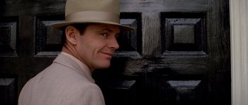 Movie still from “Chinatown” (1974), directed by Roman Polanski – A person wearing a hat near a door; Close Up shot, Low angle