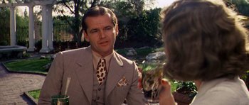 Movie still from “Chinatown” (1974), directed by Roman Polanski – A man wearing a suit and tie talking to a woman; Medium shot, Over the shoulder angle