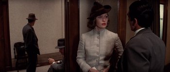 Movie still from “Chinatown” (1974), directed by Roman Polanski – A woman wearing a hat sitting on a train; Medium shot, Over the shoulder angle