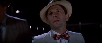 Movie still from “Chinatown” (1974), directed by Roman Polanski – A man wearing a hat and a bow tie; Close Up shot, Low angle