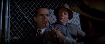 Movie still from “Chinatown” (1974), directed by Roman Polanski – A man holding a knife next to another man; Close Up shot, Over the shoulder angle