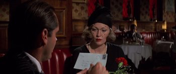 Movie still from “Chinatown” (1974), directed by Roman Polanski – An older woman in a black hat holding an envelope; Close Up shot, Over the shoulder angle