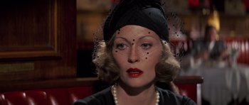 Movie still from “Chinatown” (1974), directed by Roman Polanski – A person wearing a hat with a veil; Close Up shot, Over the shoulder angle