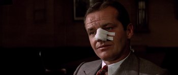 Movie still from “Chinatown” (1974), directed by Roman Polanski – A man with a bandage on his nose; Close Up shot, Low angle