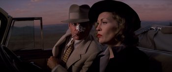 Movie still from “Chinatown” (1974), directed by Roman Polanski – A man and a woman in a suit and hat; Close Up shot, Low angle