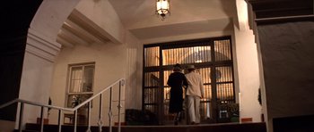 Movie still from “Chinatown” (1974), directed by Roman Polanski – Two women are walking up the stairs to the door; Wide shot, Low angle