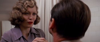 Movie still from “Chinatown” (1974), directed by Roman Polanski – A woman looking at a man in the mirror; Close Up shot, Over the shoulder angle