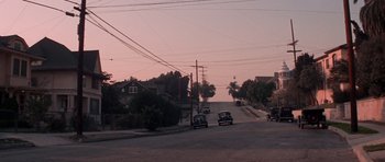 Movie still from “Chinatown” (1974), directed by Roman Polanski – Cars driving down a street at dusk with power lines overhead; Extreme Wide shot, High angle