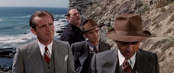 Movie still from “Chinatown” (1974), directed by Roman Polanski – A group of men standing next to each other on top of a cliff; Medium shot, Over the shoulder angle
