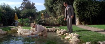 Movie still from “Chinatown” (1974), directed by Roman Polanski – Two men in suits are standing by a stream; Wide shot, High angle