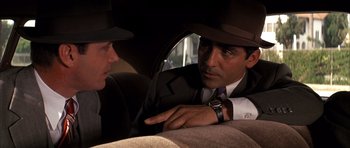Movie still from “Chinatown” (1974), directed by Roman Polanski – A man in a suit and hat talking to another man in a suit and hat; Close Up shot, Over the shoulder angle