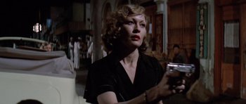 Movie still from “Chinatown” (1974), directed by Roman Polanski – A woman in a black shirt holding a cell phone; Close Up shot, Over the shoulder angle