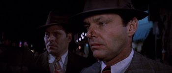 Movie still from “Chinatown” (1974), directed by Roman Polanski – A man in a suit and a man in a hat and tie; Close Up shot, Over the shoulder angle