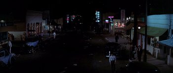 Movie still from “Chinatown” (1974), directed by Roman Polanski – A man standing on the side of a road at night; Extreme Wide shot, High angle