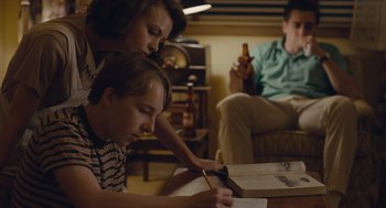Movie still from “Wildlife” (2018), directed by Paul Dano – A man and a woman sitting in a living room; Medium shot, High angle