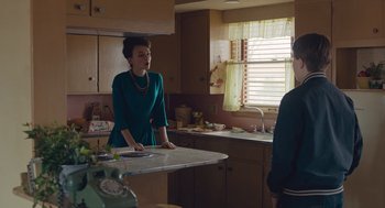 Movie still from “Wildlife” (2018), directed by Paul Dano – A woman standing in a kitchen next to a man; Medium shot, Over the shoulder angle