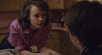 Movie still from “Wildlife” (2018), directed by Paul Dano – A young woman looking at a young man in a kitchen; Close Up shot, Over the shoulder angle