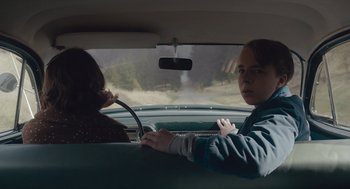 Movie still from “Wildlife” (2018), directed by Paul Dano – A man and a woman in the back seat of a car; Medium shot, Over the shoulder angle