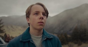Movie still from “Wildlife” (2018), directed by Paul Dano – A young man in a blue jacket looking up at the sky; Close Up shot, Low angle