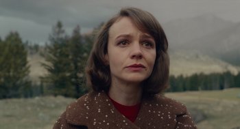 Movie still from “Wildlife” (2018), directed by Paul Dano – A woman in a brown coat looking to her left; Close Up shot, Over the shoulder angle