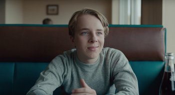 Movie still from “Wildlife” (2018), directed by Paul Dano – A man sitting on top of a wooden bench; Close Up shot, Over the shoulder angle