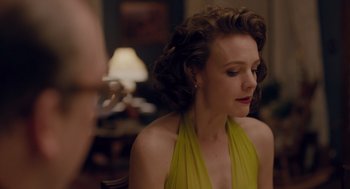 A woman in a yellow dress sitting in front of a lamp