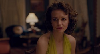 Movie still from “Wildlife” (2018), directed by Paul Dano – A woman in a yellow dress sitting in front of a lamp; Close Up shot, Over the shoulder angle