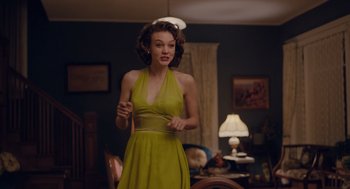 Movie still from “Wildlife” (2018), directed by Paul Dano – A woman in a green dress holding a frisbee; Medium shot, Over the shoulder angle