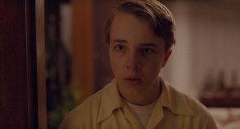 Movie still from “Wildlife” (2018), directed by Paul Dano – A young man with blonde hair wearing a white shirt; Close Up shot, Over the shoulder angle