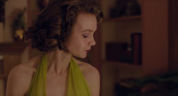 Movie still from “Wildlife” (2018), directed by Paul Dano – A woman in a yellow dress looking down at her face; Close Up shot, Low angle