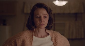 Movie still from “Wildlife” (2018), directed by Paul Dano – A woman in a white shirt and a pink sweater; Close Up shot, Over the shoulder angle
