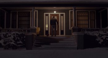 Movie still from “Wildlife” (2018), directed by Paul Dano – A man walking down the steps of a door way; Wide shot, Low angle