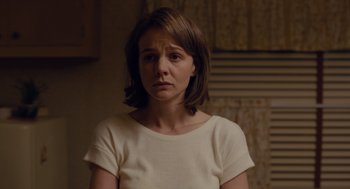 Movie still from “Wildlife” (2018), directed by Paul Dano – A woman in a white shirt is standing in a room; Close Up shot, Over the shoulder angle