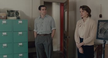 Movie still from “Wildlife” (2018), directed by Paul Dano – A man and a woman standing next to each other in a room; Medium shot, Over the shoulder angle