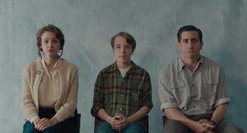 Movie still from “Wildlife” (2018), directed by Paul Dano – A group of three people sitting next to each other; Medium shot, Low angle