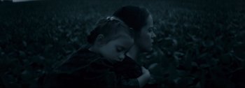 Movie still from “Women Talking” (2022), directed by Sarah Polley – A woman and a child are sitting in the grass; Close Up shot, High angle