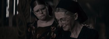 Movie still from “Women Talking” (2022), directed by Sarah Polley – Two women are looking at each other in a dark room; Close Up shot, Over the shoulder angle