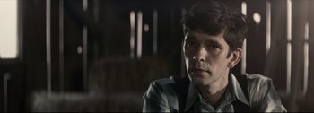 Movie still from “Women Talking” (2022), directed by Sarah Polley – A person wearing a plaid shirt; Close Up shot, Over the shoulder angle