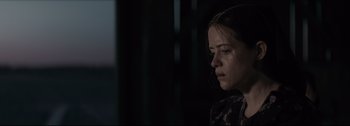Movie still from “Women Talking” (2022), directed by Sarah Polley – A young woman is looking down at her face; Close Up shot, Over the shoulder angle