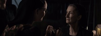 Movie still from “Women Talking” (2022), directed by Sarah Polley – A woman holding a pair of scissors in front of another woman; Close Up shot, Over the shoulder angle