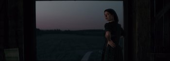Movie still from “Women Talking” (2022), directed by Sarah Polley – A woman standing in a field at night; Medium shot, Low angle