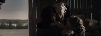 Movie still from “Women Talking” (2022), directed by Sarah Polley – An older woman hugging a young child in a dark room; Close Up shot, Over the shoulder angle