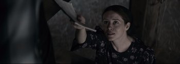 Movie still from “Women Talking” (2022), directed by Sarah Polley – A woman is holding a paper in her hand; Close Up shot, Low angle