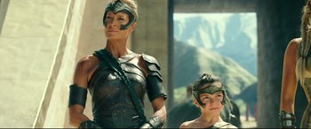 Movie still from “Wonder Woman 1984” (2020), directed by Patty Jenkins – A woman and a child dressed in costume; Medium shot, Low angle