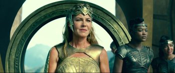 Movie still from “Wonder Woman 1984” (2020), directed by Patty Jenkins – A woman wearing a gold costume and a helmet; Close Up shot, Low angle