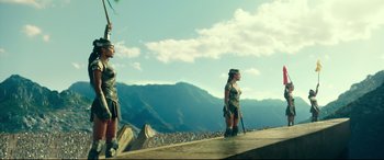 Movie still from “Wonder Woman 1984” (2020), directed by Patty Jenkins – Two women are standing on a platform in front of a mountain; Extreme Wide shot, Low angle